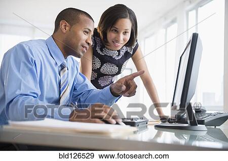 Business people talking at computer View Large Photo Image Stock Photo - Business people talking at computer. Fotosearch