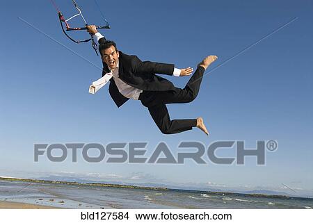 Businessman kite surfing on beach portrait View Large Photo Image Picture - Businessman kite surfing on beach portrait. Fotosearch