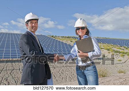 Stock Image - businessman shaking engineer's hand in solar plant. Fotosearch