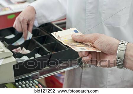 Stock Image - cash in hand of customer paying in supermarket. Fotosearch