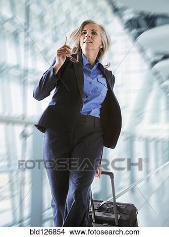 Caucasian businesswoman rushing with suitcase in airport View Large Photo Image Picture - Caucasian businesswoman rushing with suitcase in airport. Fotosearch