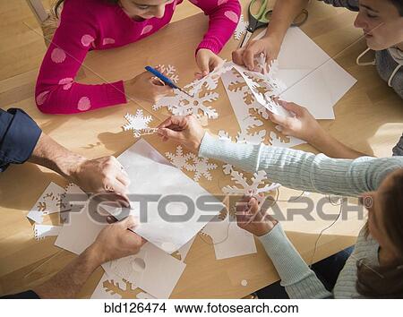 Caucasian family cutting out paper snowflakes View Large Photo Image Picture - Caucasian family cutting out paper snowflakes. Fotosearch