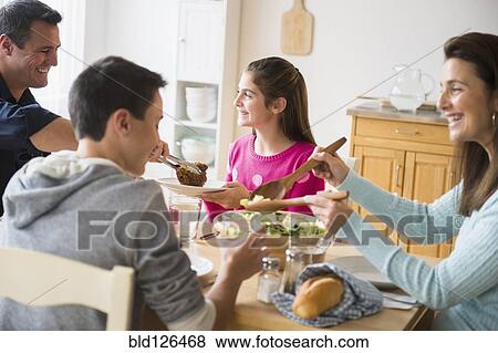Caucasian family eating at table View Large Photo Image Stock Photo - Caucasian family eating at table. Fotosearch