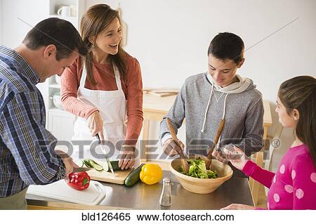Stock Photography - Caucasian family preparing salad in kitchen. Fotosearch