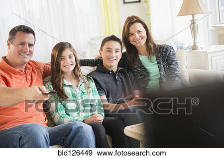 Caucasian family watching TV in living room View Large Photo Image Stock Photo - Caucasian family watching TV in living room. Fotosearch