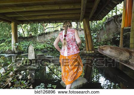 Caucasian girl walking on rocks in pond, Ubud, Bali, Indonesia View Large Photo Image Stock Photograph - Caucasian girl walking on rocks in pond, Ubud, Bali, Indonesia. Fotosearch