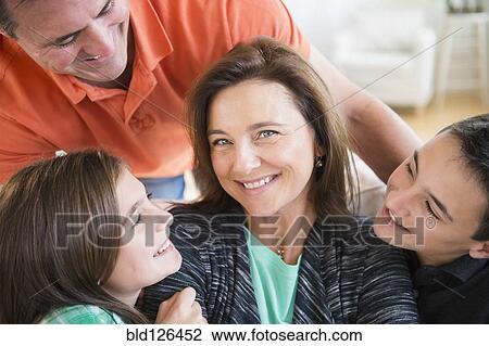 Stock Image - Caucasian man and children smiling at woman. Fotosearch