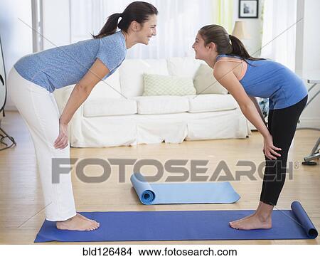Caucasian mother and daughter practicing yoga in living room View Large Photo Image Picture - Caucasian mother and daughter practicing yoga in living room. Fotosearch