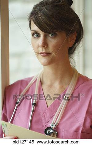 Caucasian nurse standing at window View Large Photo Image Stock Photography - Caucasian nurse standing at window. Fotosearch