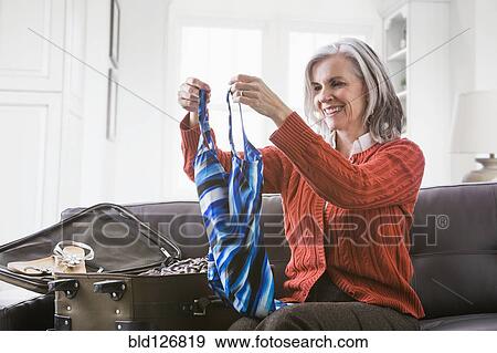 Caucasian woman packing bathing suit in suitcase View Large Photo Image Stock Photo - Caucasian woman packing bathing suit in suitcase. Fotosearch