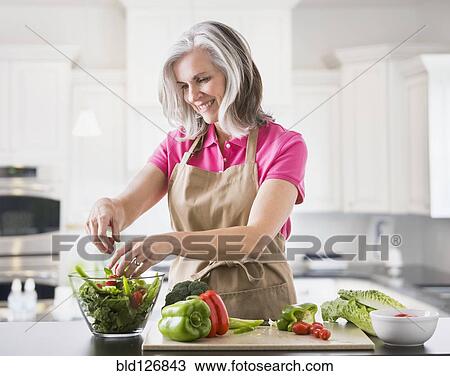 Caucasian woman preparing salad in kitchen View Large Photo Image Stock Image - Caucasian woman preparing salad in kitchen. Fotosearch