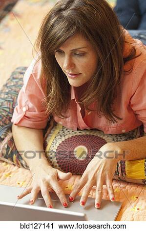 Caucasian woman using laptop on bed View Large Photo Image Stock Image - Caucasian woman using laptop on bed. Fotosearch