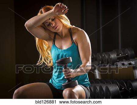 Caucasian woman wiping sweat from forehead in gym View Large Photo Image Stock Image - Caucasian woman wiping sweat from forehead in gym. Fotosearch