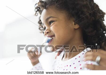 Close up of African American girl brushing teeth View Large Photo Image Stock Photo - Close up of African American girl brushing teeth. Fotosearch
