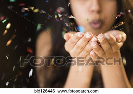 Close up of Asian woman blowing confetti from hands View Large Photo Image Stock Photograph - Close up of Asian woman blowing confetti from hands. Fotosearch