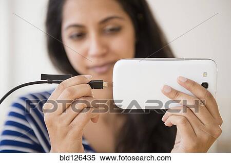 Close up of Asian woman connecting cell phone to battery View Large Photo Image Stock Photography - Close up of Asian woman connecting cell phone to battery. Fotosearch
