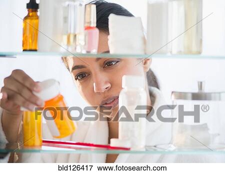 Close up of Asian woman examining label of prescription bottle View Large Photo Image Stock Photo - Close up of Asian woman examining label of prescription bottle. Fotosearch