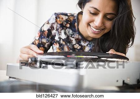 Stock Photo - Close up of Asian woman using record player. Fotosearch