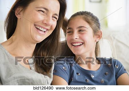 Stock Image - Close up of Caucasian mother and daughter laughing. Fotosearch