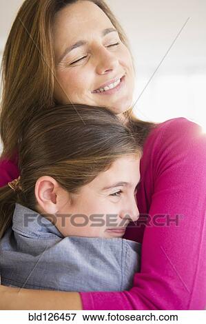 Close up of Caucasian mother and daughter hugging View Large Photo Image Stock Photo - Close up of Caucasian mother and daughter hugging. Fotosearch