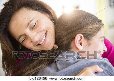 Stock Photograph - Close up of Caucasian mother and daughter hugging. Fotosearch