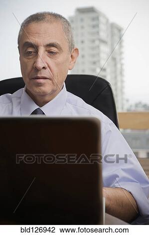 Close up of Hispanic man using laptop in urban office View Large Photo Image Stock Image - Close up of Hispanic man using laptop in urban office. Fotosearch