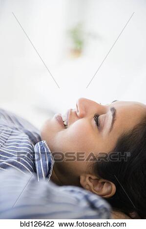 Close up of serene Asian woman laying with hands behind head View Large Photo Image Stock Image - Close up of serene Asian woman laying with hands behind head. Fotosearch