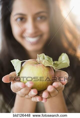 Stock Photo - Close up portrait of Asian woman holding fresh apple. Fotosearch
