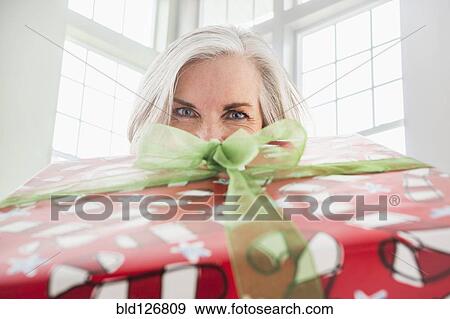 Stock Photo - Close up portrait of Caucasian woman with Christmas gift. Fotosearch