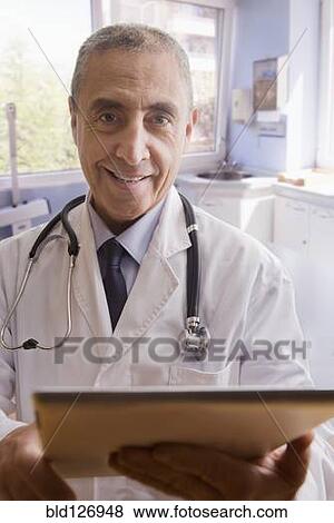 Close up portrait of smiling Hispanic doctor with digital tablet View Large Photo Image Stock Photo - Close up portrait of smiling Hispanic doctor with digital tablet. Fotosearch