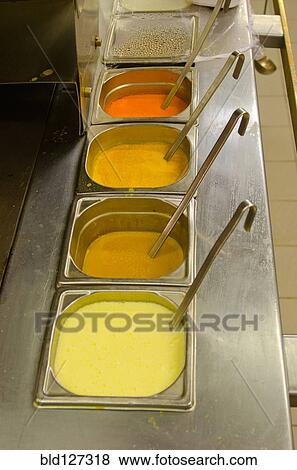 Colored sauces with ladles in restaurant kitchen View Large Photo Image Stock Photo - Colored sauces with ladles in restaurant kitchen. Fotosearch