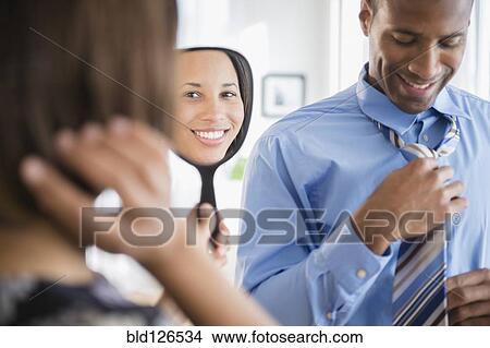 Picture - Couple getting ready dressed. Fotosearch