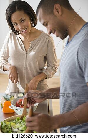 Stock Image - Couple preparing salad. Fotosearch