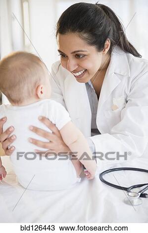 Doctor smiling at baby View Large Photo Image Stock Image - Doctor smiling at baby. Fotosearch