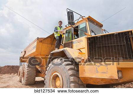 Engineer on dump truck in construction site View Large Photo Image Picture - Engineer on dump truck in construction site. Fotosearch
