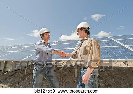 Stock Photo - engineers shaking hands in solar plant. Fotosearch