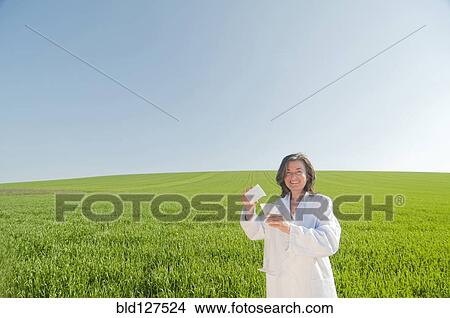 female scientist with test tube in green field View Large Photo Image Picture - female scientist with test tube in green field. Fotosearch