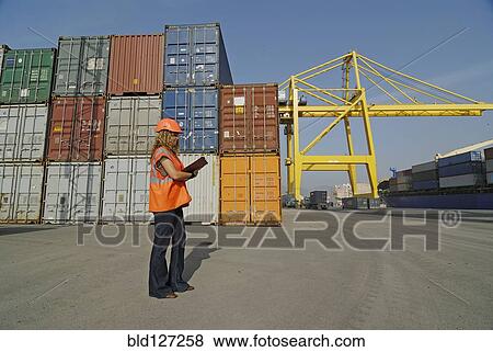 Female worker with clipboard in cargo container terminal View Large Photo Image Stock Photo - Female worker with clipboard in cargo container terminal. Fotosearch