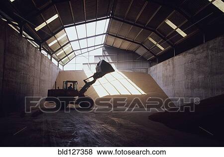 Front-end loader in grain warehouse View Large Photo Image Stock Photo - Front-end loader in grain warehouse. Fotosearch