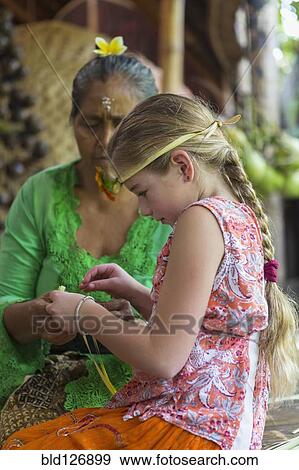 Stock Photo - Girl learning Balinese weaving, Ubud, Bali, Indonesia. Fotosearch