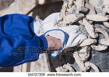 Stock Photograph - gloved hand gripping chain. Fotosearch