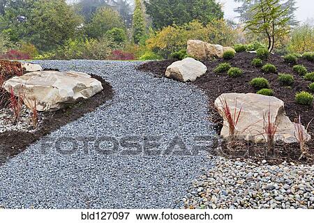 Stock Photo - Gravel path and rocks in landscaped garden. Fotosearch
