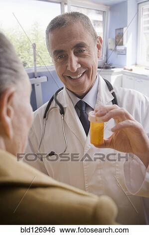 Hispanic doctor giving patient prescription bottle View Large Photo Image Stock Photograph - Hispanic doctor giving patient prescription bottle. Fotosearch