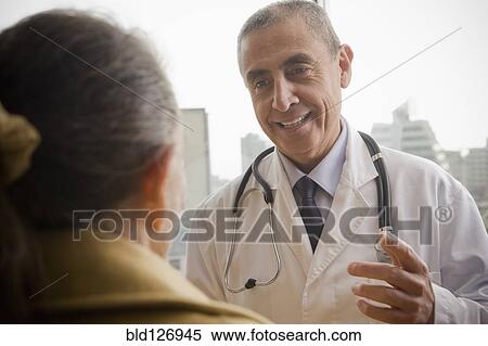 Stock Photography - Hispanic doctor talking to patient. Fotosearch