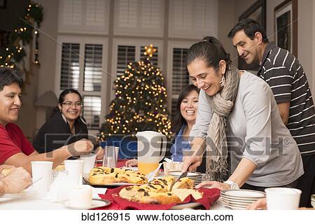 Stock Photography - Hispanic family enjoying traditional Christmas dessert. Fotosearch