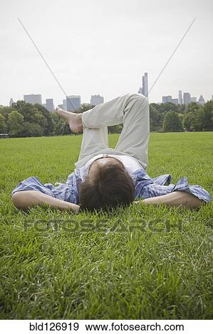 Hispanic man laying in grass at park View Large Photo Image Stock Photo - Hispanic man laying in grass at park. Fotosearch