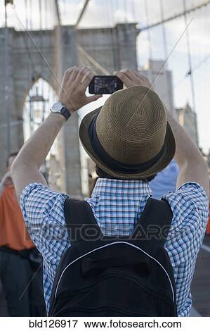 Hispanic man photographing Brooklyn Bridge, New York City, New York, United States View Large Photo Image Stock Photo - Hispanic man photographing Brooklyn Bridge, New York City, New York, United States. Fotosearch