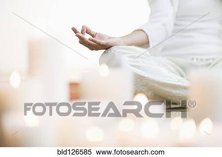 Hispanic woman meditating in lotus position near lit candles View Large Photo Image Stock Photography - Hispanic woman meditating in lotus position near lit candles. Fotosearch