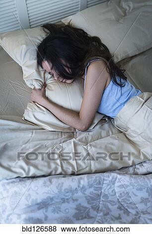 Stock Photo - Hispanic woman sleeping in bed. Fotosearch