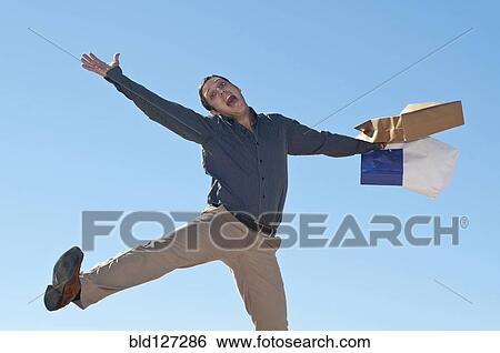 jumping man with shopping bags View Large Photo Image Stock Photograph - jumping man with shopping bags. Fotosearch